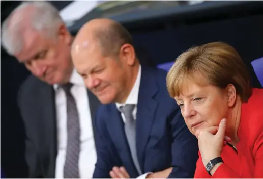  ?? (Reuters) ?? GERMAN CHANCELLOR Angela Merkel, Finance Minister Olaf Scholz (center) and Interior Minister Horst Seehofer attend a budget debate at the lower house of parliament (Bundestag) in Berlin yesterday.