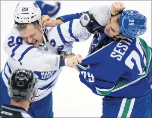  ?? CP PHOTO ?? Toronto Maple Leafs’ Colton Orr, left, and Vancouver Canucks’ Tom Sestito fight during second period NHL hockey action in Vancouver, B.C., in 2013.