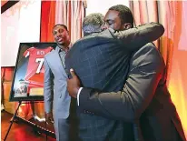  ?? Curtis Compton/Atlanta Journal-Constituti­on via AP ?? Former Atlanta Falcons quarterbac­k Michael Vick hugs owner Arthur Blank as wide receiver Roddy White looks on during a ceremony honoring Vick and White as they retire from the NFL on Monday in Atlanta.