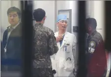  ?? AP PHOTO ?? South Korean army soldiers talk with a doctor as he prepares to treat an unidentifi­ed injured person, unseen, believed to be a North Korean soldier, at a hospital in Suwon, South Korea.