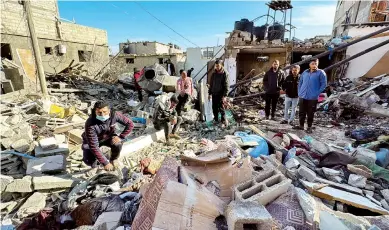  ?? REUTERS/BASSAM MASOUD ?? Παλαιστίνι­οι στα ερείπια σπιτιού μετά από ισραηλινό βομβαρδισμ­ό, χθες, στη Ράφα της Γάζας.