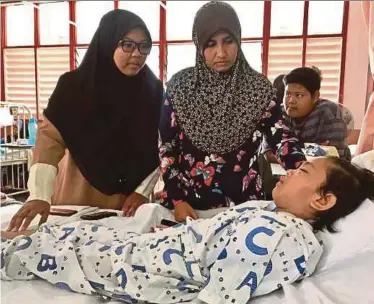  ?? PIC BY GHAZALI KORI ?? Nur Zulaikha Khumaira Zulkifli recovering from a surgery in Kuala Terengganu yesterday. With her is Nur Zulaikha’s mother, Rohidayu Siup@Yusof (second from left).