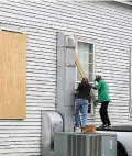  ?? Brad Kemp/The Advocate via AP ?? The Rev. Ivory Williams Sr. and Chris Welch board up the windows of St. John Baptist Church while prepping for Hurricane Delta on Thursday in Charenton, La.