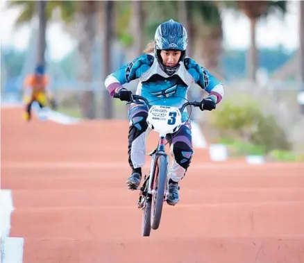  ?? PHOTOS BY GARY CURRERI ?? Above, Coral Springs’ BMX racer Heather Nicole Munive powers her way to the first of her two state titles in the Girls 21-25 Division at Okeeheelee Park in West Palm Beach. Below, Ryder Faoro, of Coral Springs, had a fourth-place showing in the Boys 11...