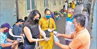  ??  ?? Residents sanitise their hands before entering a weekly fruit and vegetable market at Marine Drive, on Saturday.