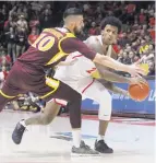  ??  ?? LEFT: The Lobos’ Vance Jackson, at right, looks to pass around Iona’s Andrija Ristanovic during UNM’s victory at Dreamstyle Arena.