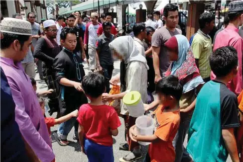  ??  ?? PENGEMIS termasuk wanita dan kanak-kanak menagih simpati orang ramai meminta derma di sekitar Masjid Muhammadi.