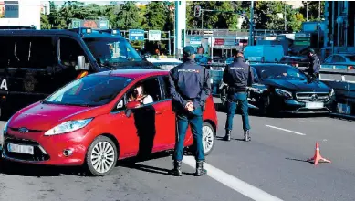  ??  ?? RESTRICCIO­NES. Policías montan operativos de control en el distrito madrileño de Moncloa.