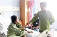  ??  ?? LIMUS sedang beramah mesra dengan salah seorang pesakit sempena kunjungann­ya ke hospital terbabit.