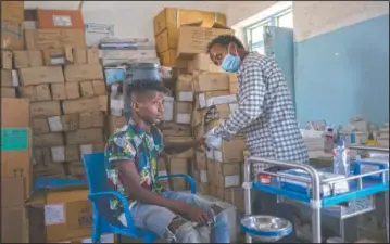  ??  ?? Seid Mussa Omar, a 29-year-old Tigrayan nurse from Humera, treats a man at the Sudanese Red Crescent clinic in Hamdayet.