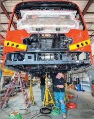  ?? ZHANG CHAOQUN / XINHUA ?? Workers install wiring in an electric bus at a BYD factory in Lancaster, California, in September 2016.