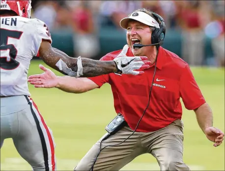  ?? CURTIS COMPTON / CCOMPTON@AJC.COM ?? UGA coach Kirby Smart celebrates with running back Brian Herrien after he went over the top of South Carolina defenders for a touchdown during the Bulldogs’ high-scoring, dominant third quarter Saturday. Georgia won the game 41-17.