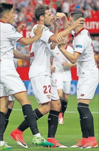  ??  ?? DOBLETE. Los jugadores de Sevilla abrazan a Franco Vázquez tras el primero de sus dos goles.