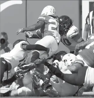  ?? TIM WARNER/GETTY-AFP ?? TCU’s Garret Wallow (30) forces a fumble by Texas’ Keaontay Ingram on the goal line late in the fourth quarter.