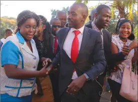  ?? The Associated Press ?? Opposition leader Nelson Chamisa, centre, is greeted by supporters during a visit to see election-related violence victims at a hospital in Harare, Zimbabwe, Thursday. Zimbabwe's acting president said Thursday that his government had been in touch with...