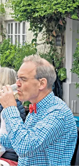  ?? ?? Villagers in Cerne Abbas, Dorset, raise a glass to the Queen at their Platinum Jubilee street party, yesterday, left; Camilla, Duchess of Cornwall, admires a celebrator­y cake made out of felt as she attends the Big Jubilee Lunch with the Prince of Wales, at the Oval in south London