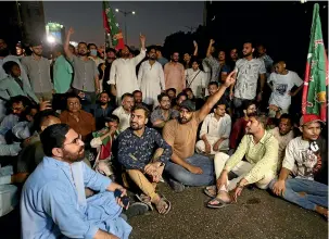  ?? AP ?? Supporters of former Pakistani prime minister Imran Khan’s party, Pakistan Tehreek-e-Insaf, chant slogans as they block a road during a protest to condemn his shooting.