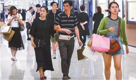  ?? South China Morning Post ?? Shoppers walk in Harbour City in Tsim Sha Tsui. Two thirds of Hong Kong consumers say they have more clothes than they need and half have clothes that have never been worn and are still carrying their sales tags.