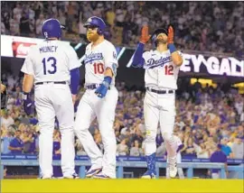  ?? Mark J. Terrill Associated Press ?? JOEY GALLO, right, gestures after hitting a three-run home run in the second against the Giants as Max Muncy and Justin Turner wait for him at home plate.