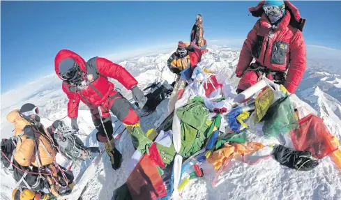  ?? AFP ?? Mountainee­rs and sherpas gather at the summit of Everest after ascending on the south face from Nepal last month.