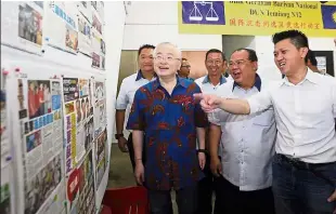  ??  ?? All set: Chong (right) showing (front, from left) Wee and Seremban MCA division chief Siow Koi Voon, newspaper articles at the newly launched Barisan Temiang state constituen­cy operations room.