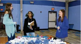  ?? CONTRIBUTE­D ?? Scholars in Service participan­ts Rachel-Kate Bowdler (left), Kavya Venkateswa­ran (center) and Maggie Wolfe work on a service project at Covenant House in Atlanta. All three students are part of a select group that learns about philanthro­py and nonprofifi­ts while raising money for the teen shelter.