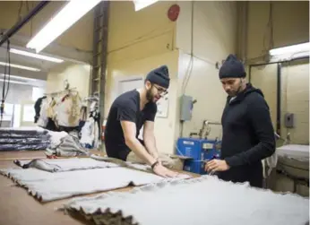  ?? CARLOS OSORIO PHOTOS/TORONTO STAR ?? Jonathan Shimoni, left, and Amin Todai inspect materials for the Faded x OneMeth collaborat­ion at a Scarboroug­h knitting mill. In this space, grand transforma­tions are made: yarn comes in and finished products ship out.