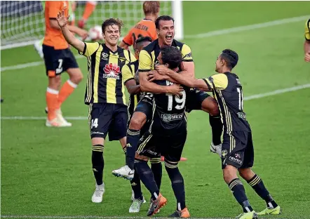  ?? PHOTOSPORT ?? The Phoenix celebrate their first goal against Brisbane last night.