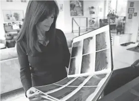  ?? RICK WOOD / MILWAUKEE JOURNAL SENTINEL ?? Lillian Williamson looks at a scrapbook of photos of the land that would become Erin Hills.