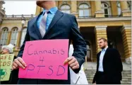  ?? MICHAEL ZAMORA ?? AP PHOTO BY In this 2015 file photo, a Marine veteran holds a sign to show support for cannabis for post traumatic stress disorder sufferers, outside the State Capitol in Des Moines, Iowa.