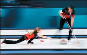  ?? THE CANADIAN PRESS/NATHAN DENETTE ?? Kaitlyn Lawes, left, throws the rock as teammate John Morris sweeps during mixed doubles curling action again Norway at the XXIII Olympic Winter Games in Gangneung, South Korea on Thursday. Canada lost 9-6.