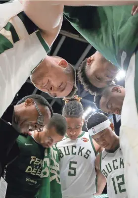  ?? MIKE DE SISTI / MILWAUKEE JOURNAL SENTINEL ?? Bucks players gather in prayer Friday night after their Game 2 victory over the Raptors at Fiserv Forum.