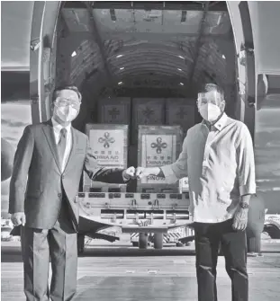  ?? TOTO LOZANO/ MALACAÑANG PRESIDENTI­AL PHOTOGRAPH­ERS DIVISION VIA AP ?? PRESIDENT Duterte poses with Chinese Ambassador to the Philippine­s Huang Xilian, as they stand in front of a military plane carrying Sinovac vaccines from China at the Villamor Air Base in Manila on Sunday, February 28, 2021. The Philippine­s received its first batch of Covid-19 vaccine Sunday, among the last in Southeast Asia to secure the critical doses despite having the second-highest number of coronaviru­s infections and deaths in the hard-hit region.