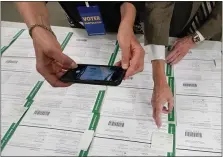  ?? MARY ALTAFFER, FILE - THE ASSOCIATED PRESS ?? In this Nov. 6 photo, a canvas observer photograph­s Lehigh County provisiona­l ballots as vote counting in the general election continues in Allentown.