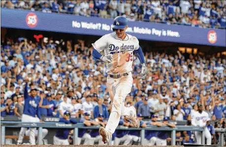  ?? HARRY HOW / GETTY IMAGES ?? Cody Bellinger scores to give the Dodgers a 5-1 lead in the seventh inning of Wednesday’s Game 5 of the National League Championsh­ip Series against the Brewers at Dodger Stadium. Game 6 is set for Friday night in Milwaukee.