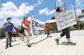  ?? DYLAN SLAGLE/BALTIMORE SUN MEDIA ?? Protesters march outside the George Howard Building in Ellicott City on June 22, 2020, to demand Howard County end its agreement with ICE to house detainees at the Howard County Detention Center.