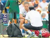  ??  ?? Martin Klizan receives medical attention during his Wimbledon first round match against Novak Djokovic on Tuesday. REUTERS