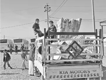  ??  ?? Iraqis displaced due to fighting between federal forces and Kurdish peshmerga fighters leave a camp for internally displaced people (IDP) in Daquq as they head back to Kirkuk. — AFP photo