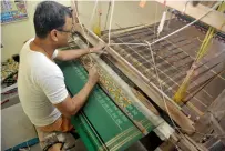  ?? AFP file ?? An artisan weaves fabric on a handloom at his household workshop at Koyalagude­m village, near Hyderabad. —