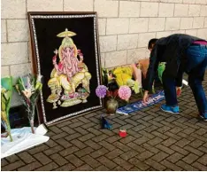  ?? Foto: Aaron Chon, dpa ?? Anhänger des englischen Fußball-Erstligist­en Leicester City legen am Stadion Blumen und Schals nieder.