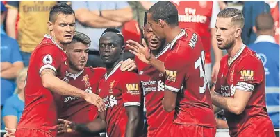  ?? Picture: PA. ?? Sadio Mane, third left, is congratula­ted by his Liverpool team-mates after giving the hosts a 2-0 lead at half-time.