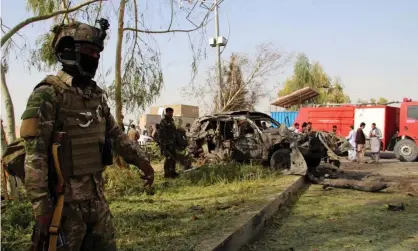  ??  ?? Afghan security officials inspect the scene of a bomb blast in Lashkar Gah, the provincial capital of Helmand province, on Saturday. Photograph: Watan Yar/EPA