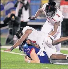  ?? [AP PHOTO] ?? Kansas long snapper Logan Klusman recovers a fumble under Texas Tech linebacker Xavier Benson and defensive back Douglas Coleman III , setting up the game-winning field goal.