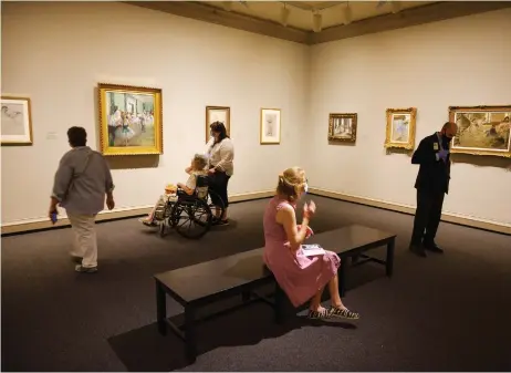  ??  ?? Museum-goers look at works hanging in the ‘Degas at the Opera’ exhibit at the newly reopened National Gallery of Art in Washington, DC.