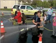  ?? SUBMITTED PHOTO – EAST BRANDYWINE FIRE COMPANY ?? East Brandywine Fire Company volunteers hosted an open house event on Wednesday. Firefighte­rs assisted kids to extinguish a simulated house fire.