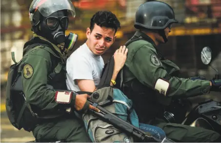  ?? Ronaldo Schemidt / AFP / Getty Images ?? An antigovern­ment activist is arrested during clashes Friday in Caracas. More than 110 people have been killed in recent clashes.