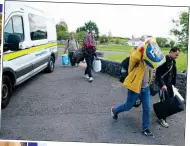  ?? ?? had enough: Refugees leaving their accomodati­on in Inch, Co. Clare