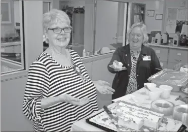  ?? Doug Walker ?? Jackie Crowe (left) and Barbara Penson get a laugh over the size of the retirement cake slice Crowe cut for Penson on Friday. Crowe retired Friday after 45 years with the county.