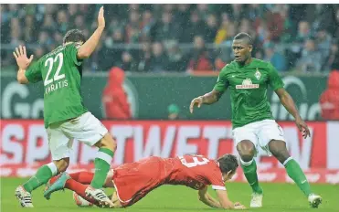  ?? FOTO: DPA ?? Fortunas Ex-Spieler Robbie Kruse im November 2012 gegen die Bremer Sokratis (li.) und Assani Lukimya (re.).