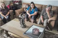 ?? NIC COURY THE ASSOCIATED PRESS ?? Family members of Jerry Ramos become emotional when looking at a photo of him at the family home in Watsonvill­e, Calif., on Sunday. He died Feb. 15 at age 32, becoming one of the roughly 600,000 Americans who have perished due to COVID.